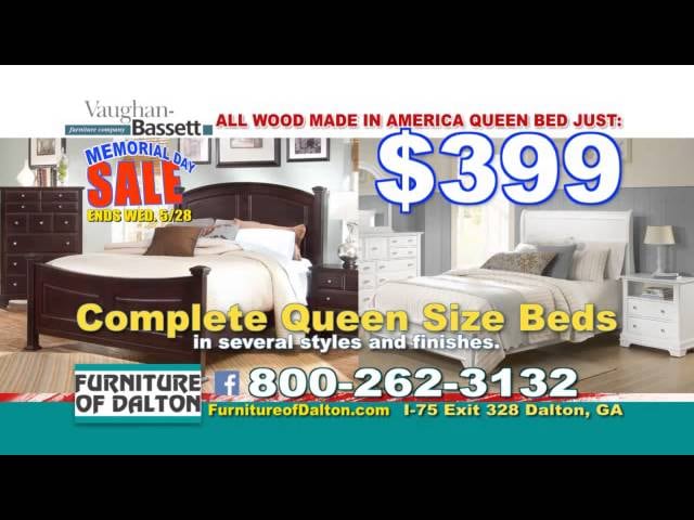Frame from a commercial: a queen bedroom set with a sale price graphic and the store's phone number