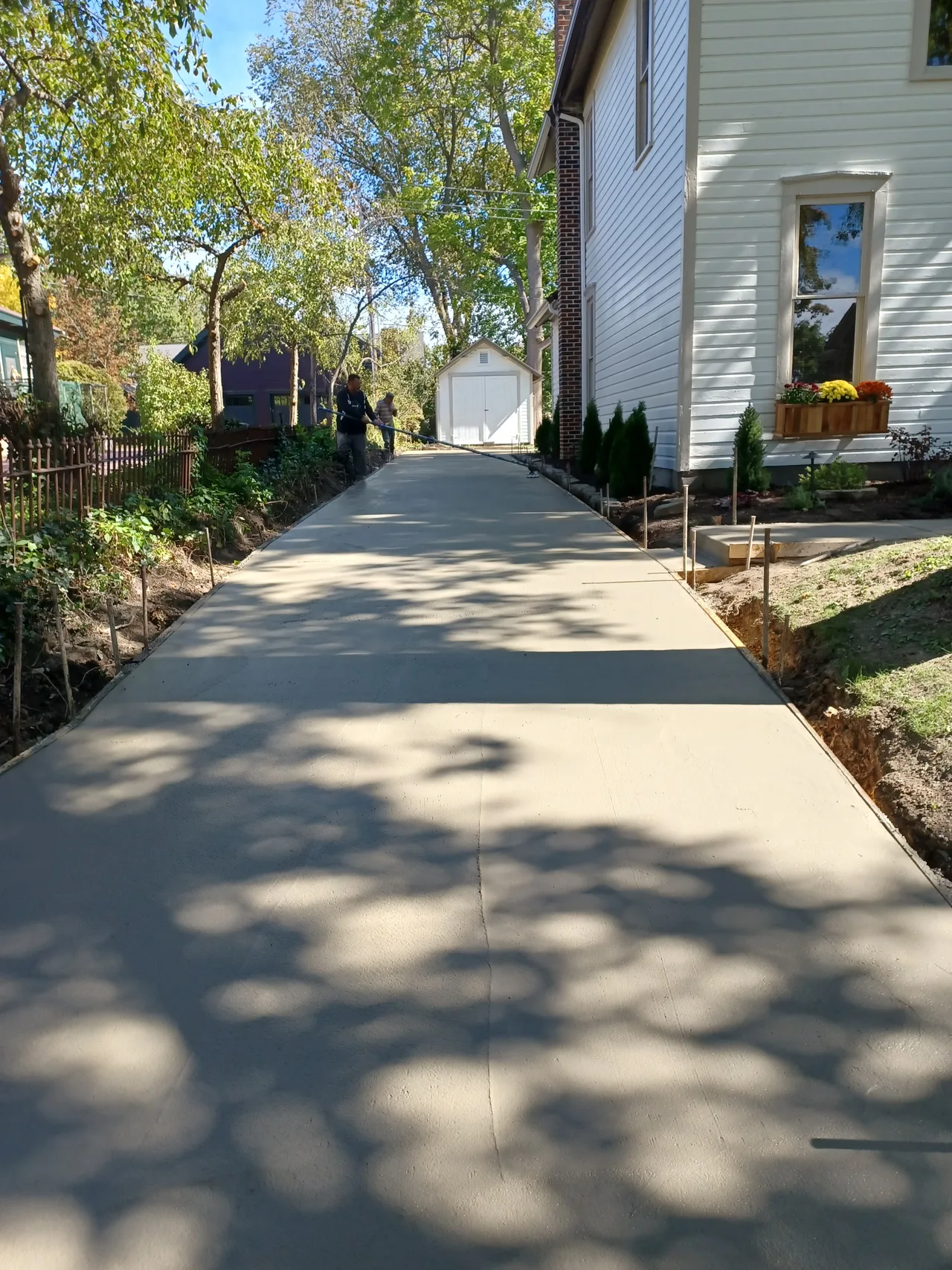 Mattucci Construction crew finishing a new concrete driveway pour beside a residential home near Hudson, Ohio (real jobsite photo)
