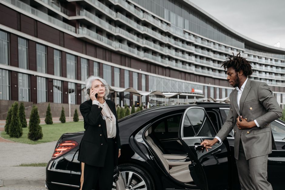 Professional services | Premier Private Rides personal chauffeur waiting outside a limo